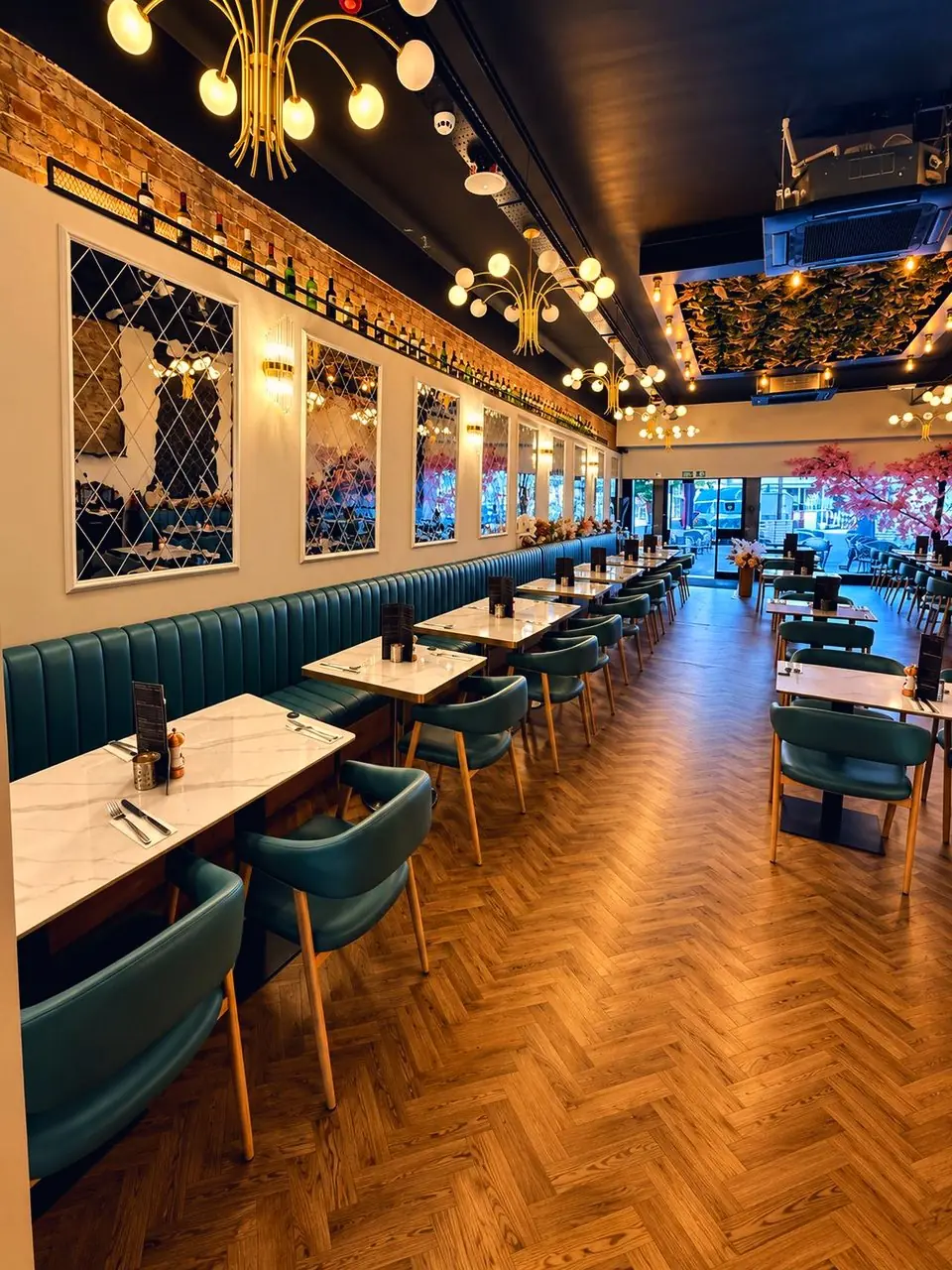 Marble tables laid along Jenny's teal banquettes