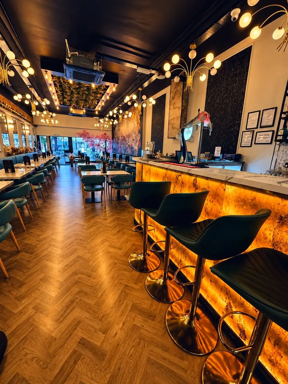 Teal velvet stools along the glowing onyx bar