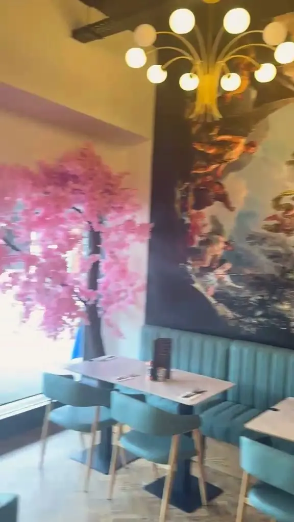 Pink blossom by the window over the teal banquettes