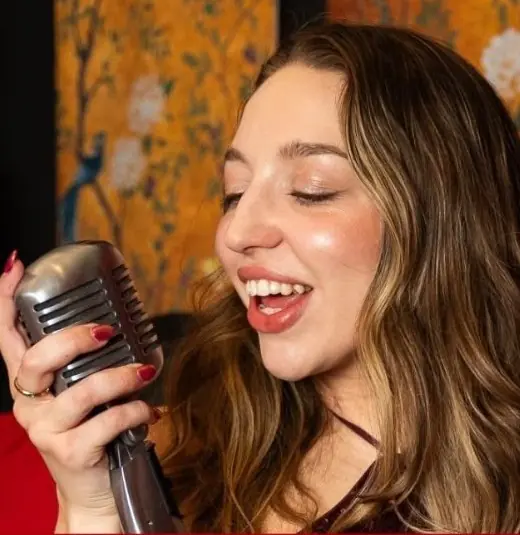 Olivia Beall singing at a vintage microphone