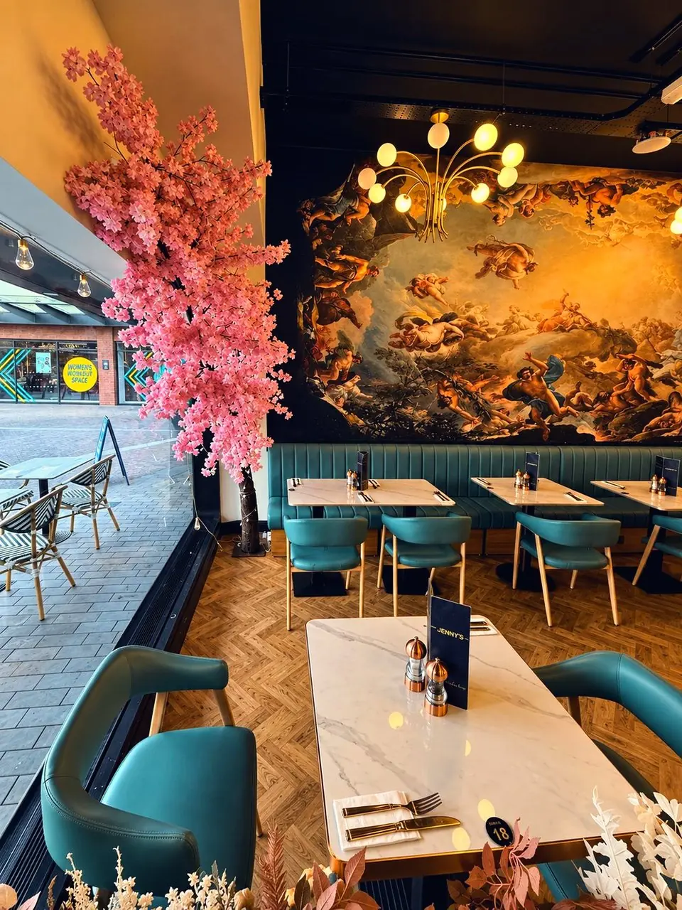 The painted sky over the teal banquettes, blossom by the window